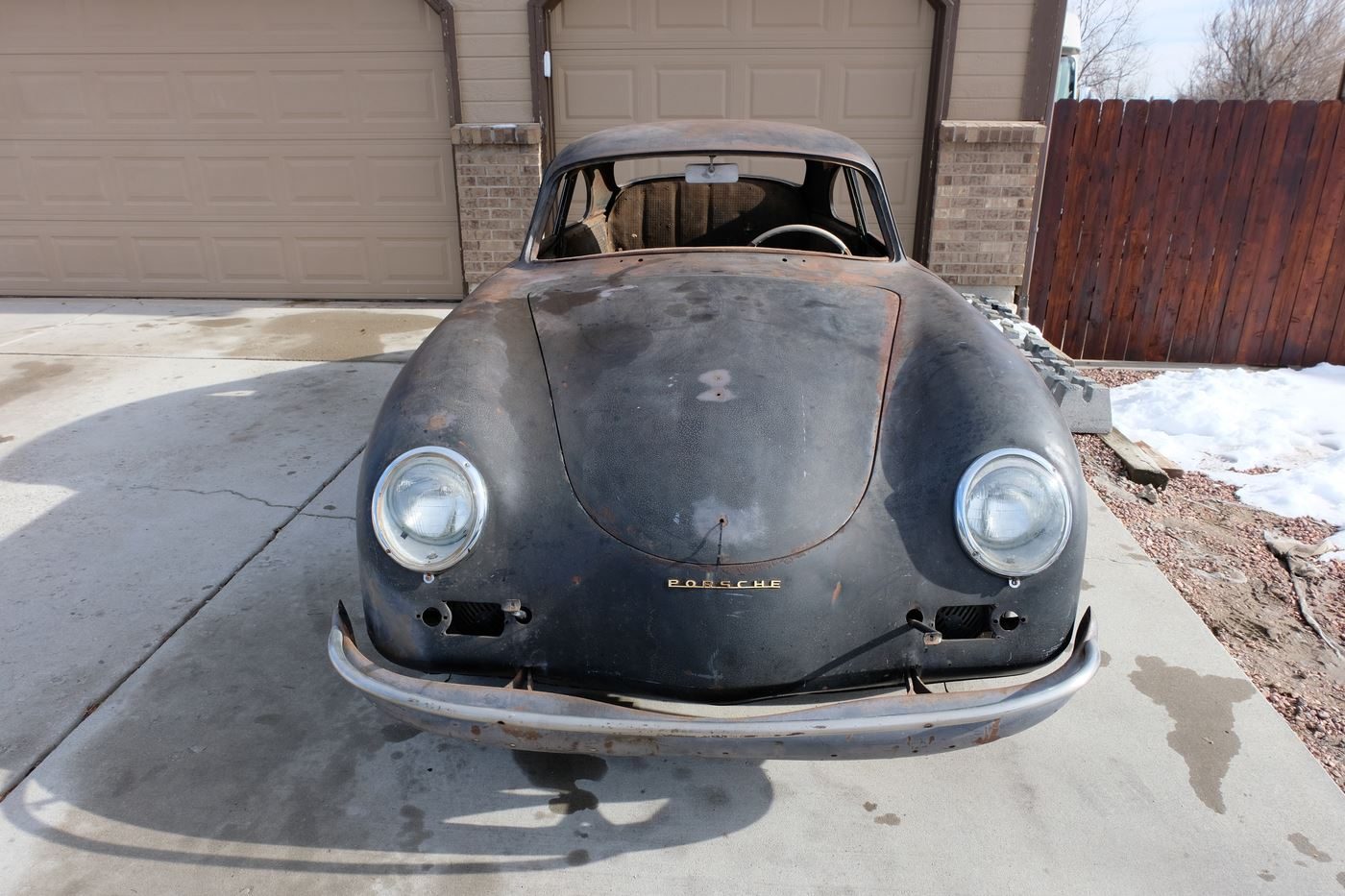 The stripped, black-painted 356 as found, front three-quarter view in snow