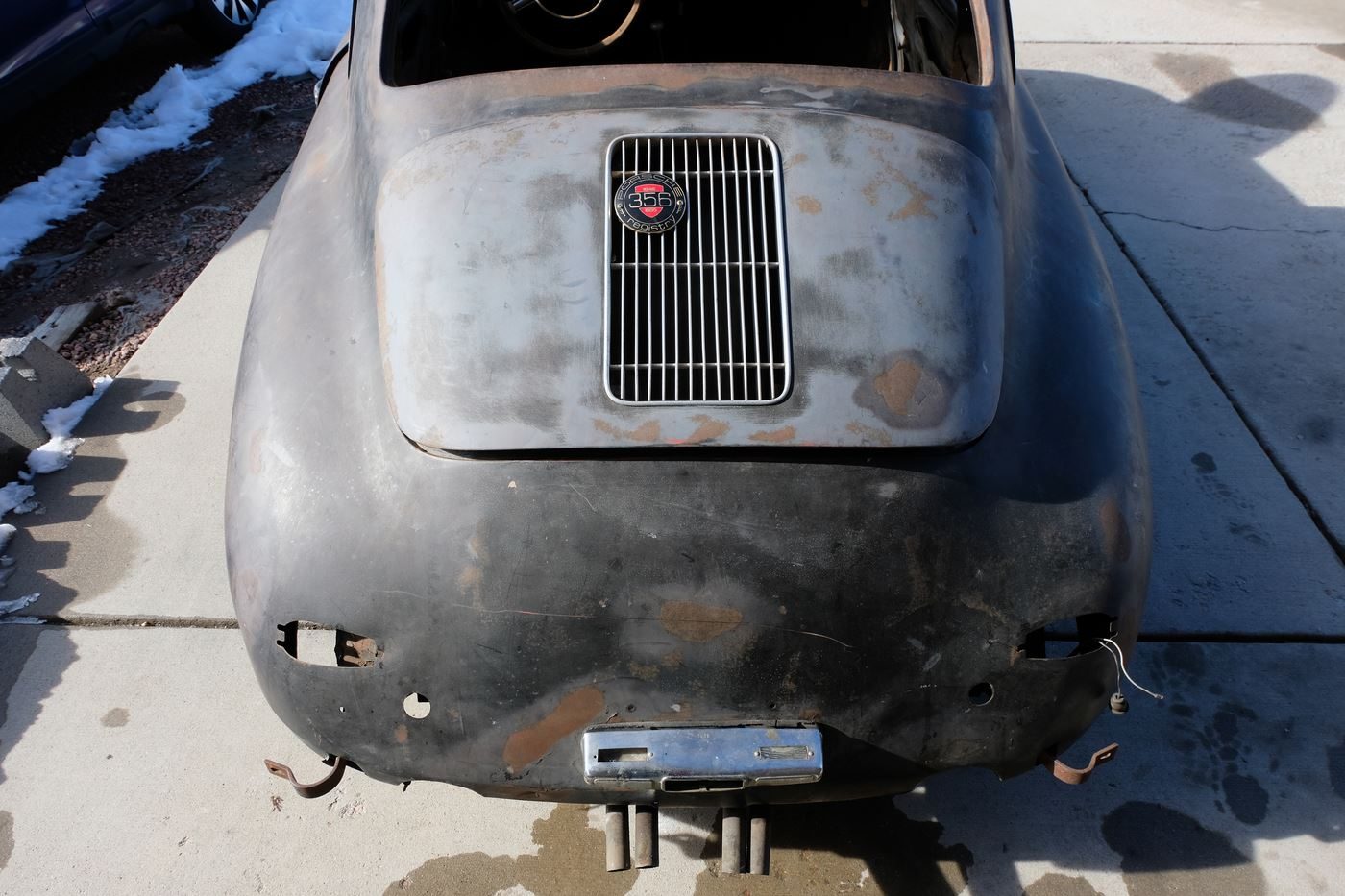 The stripped, black-painted 356 as found, rear view in snow