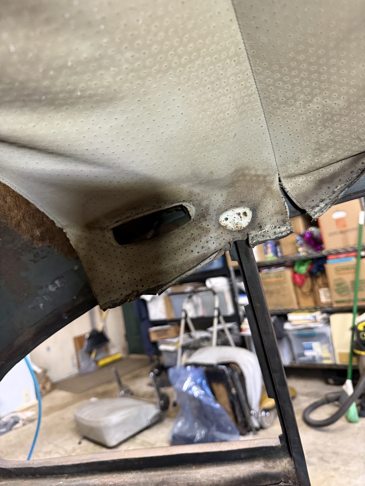 Rusted fender detail, shop shelving in the background