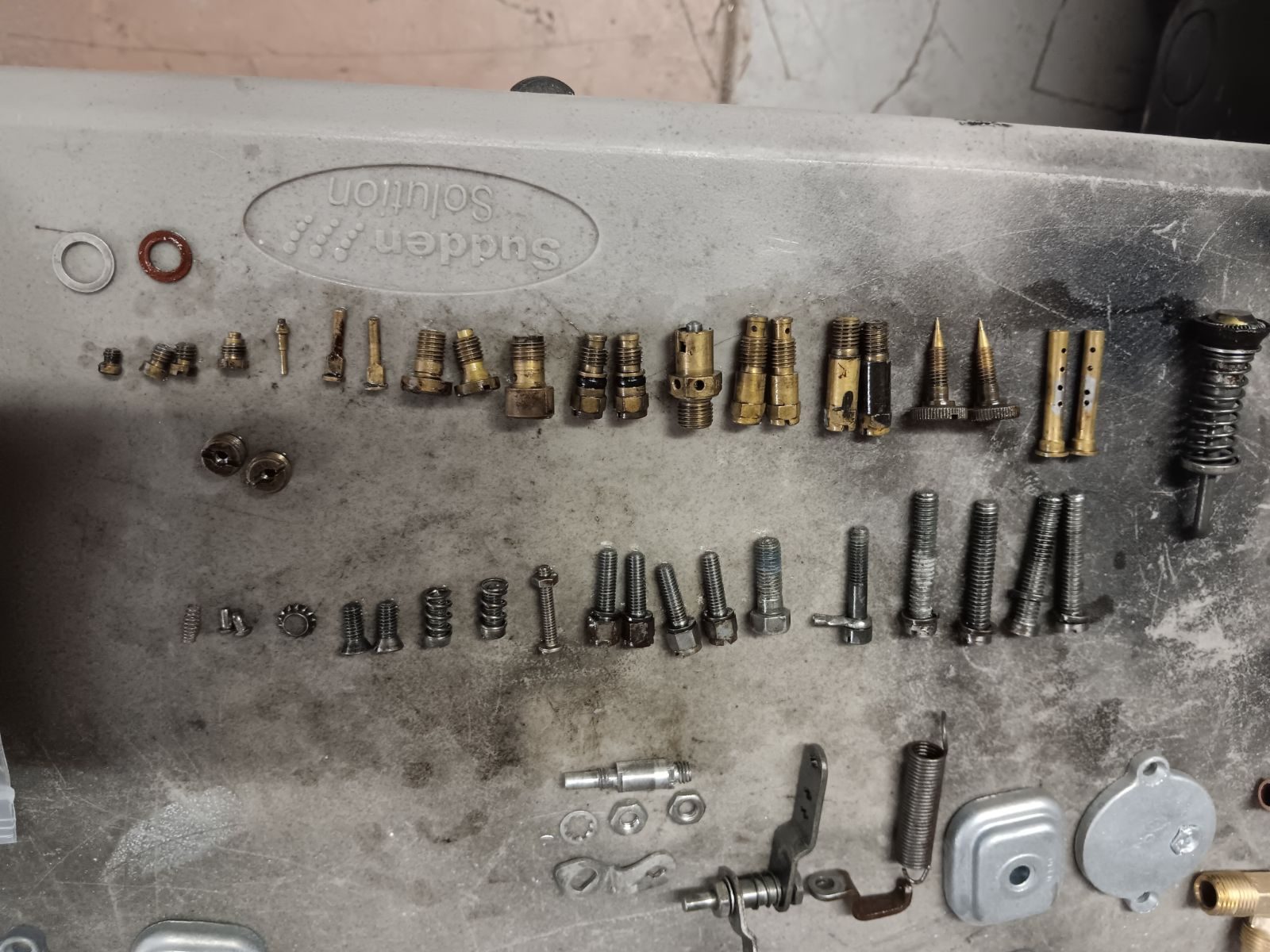 Jets, screws and hardware laid out in disassembly order