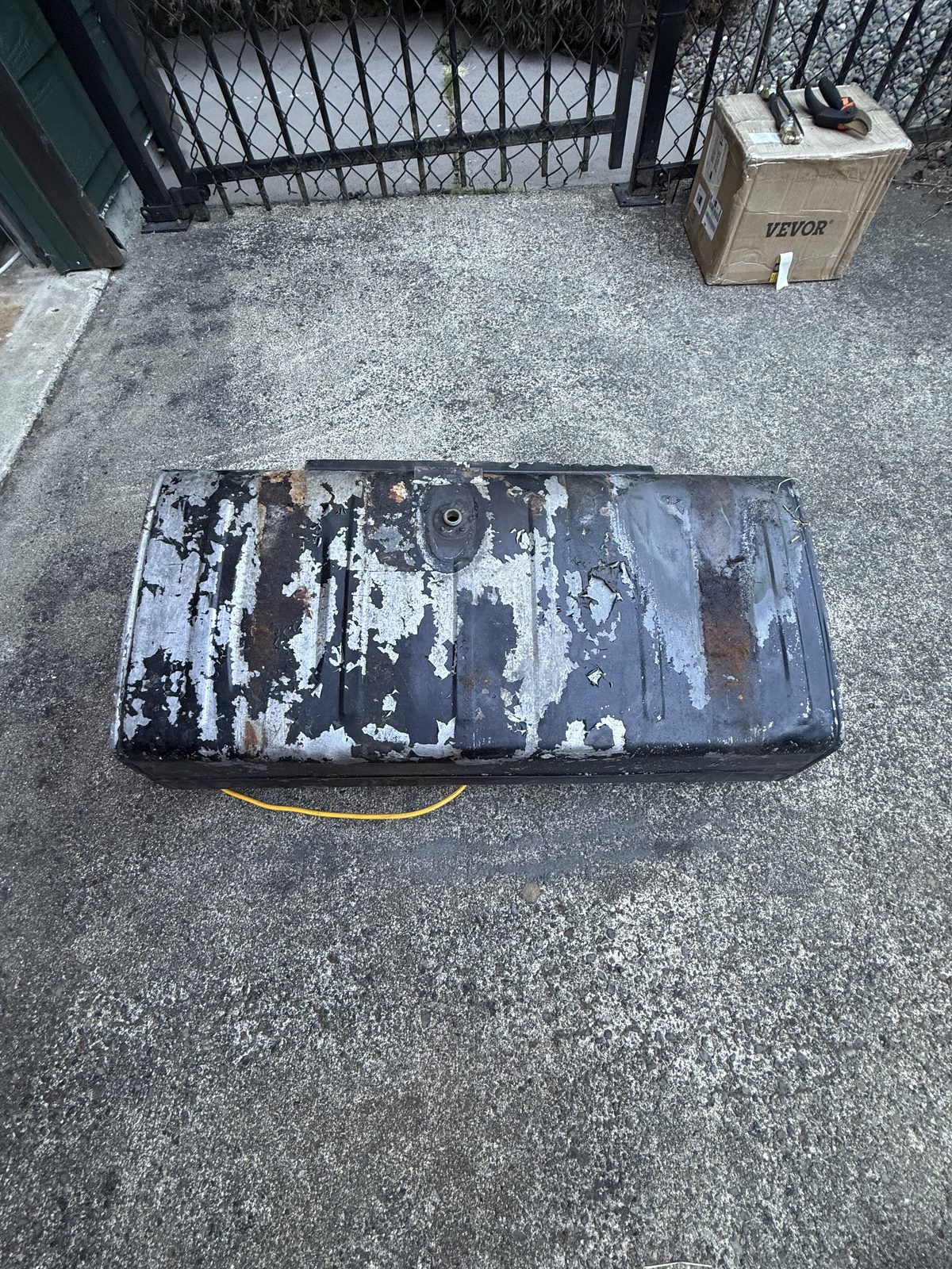 Fuel tank removed, showing the underside and flaking exterior paint